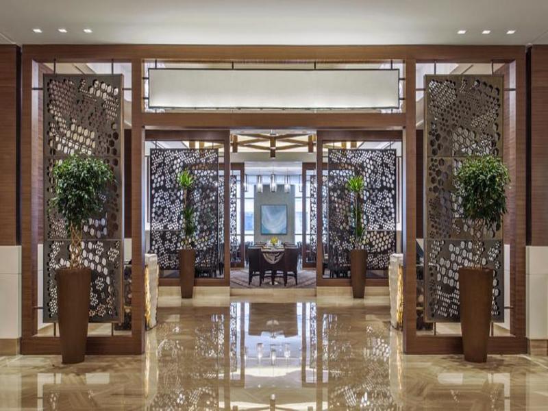 מלון מכה Jabal Omar Hyatt Regency Makkah מראה חיצוני תמונה The photo depicts the interior of an elegant restaurant or lobby space. There are large decorative partitions that create a sense of separation and intimacy, featuring intricate designs. On either side of the partitions, there are tall decorative pla
