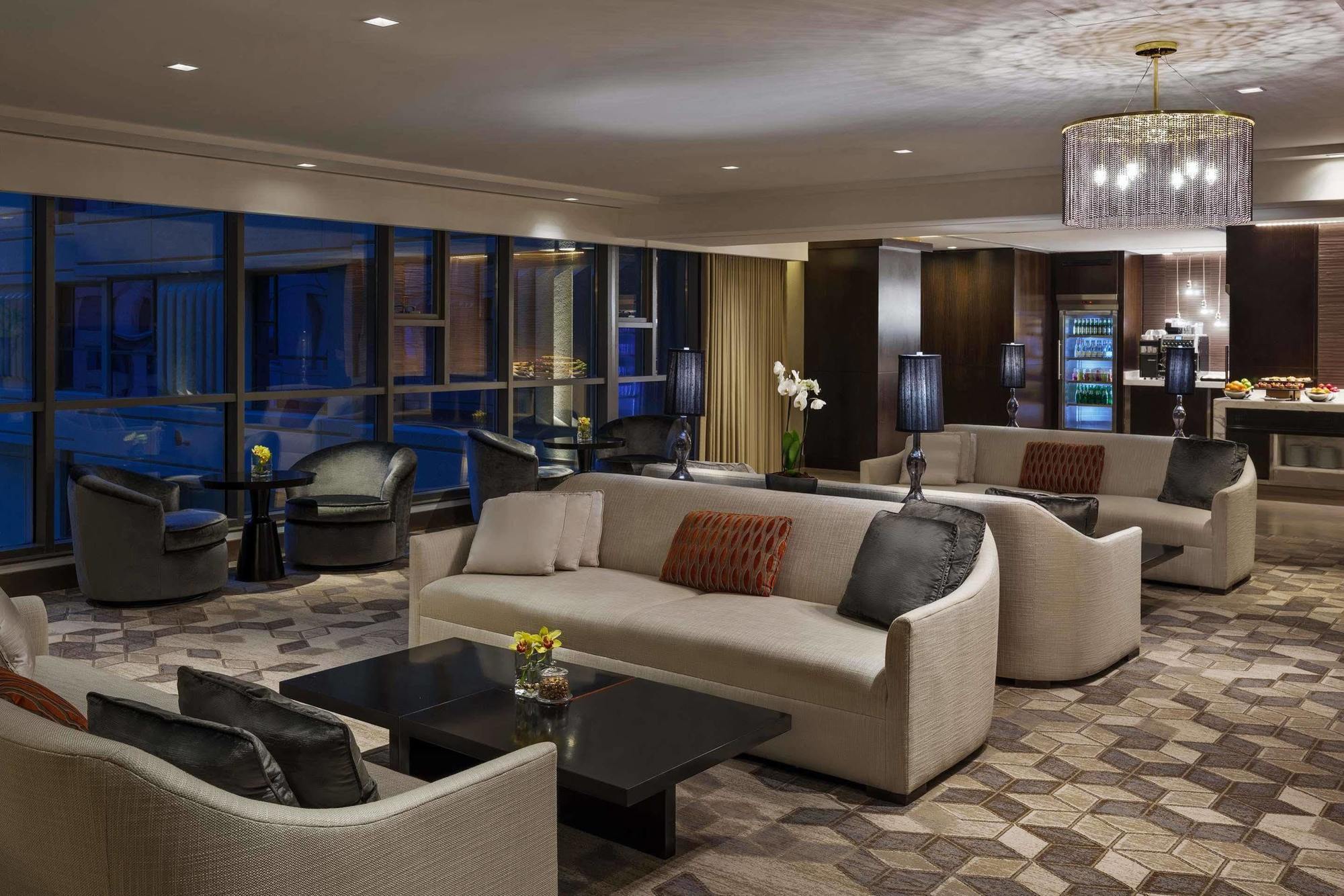 מלון מכה Jabal Omar Hyatt Regency Makkah מראה חיצוני תמונה The photo shows a modern and elegant lounge area. It features comfortable cream-colored sofas arranged in a cozy setting, along with dark coffee tables. The space is illuminated by warm lighting, including a stylish chandelier. Large windows allow fo